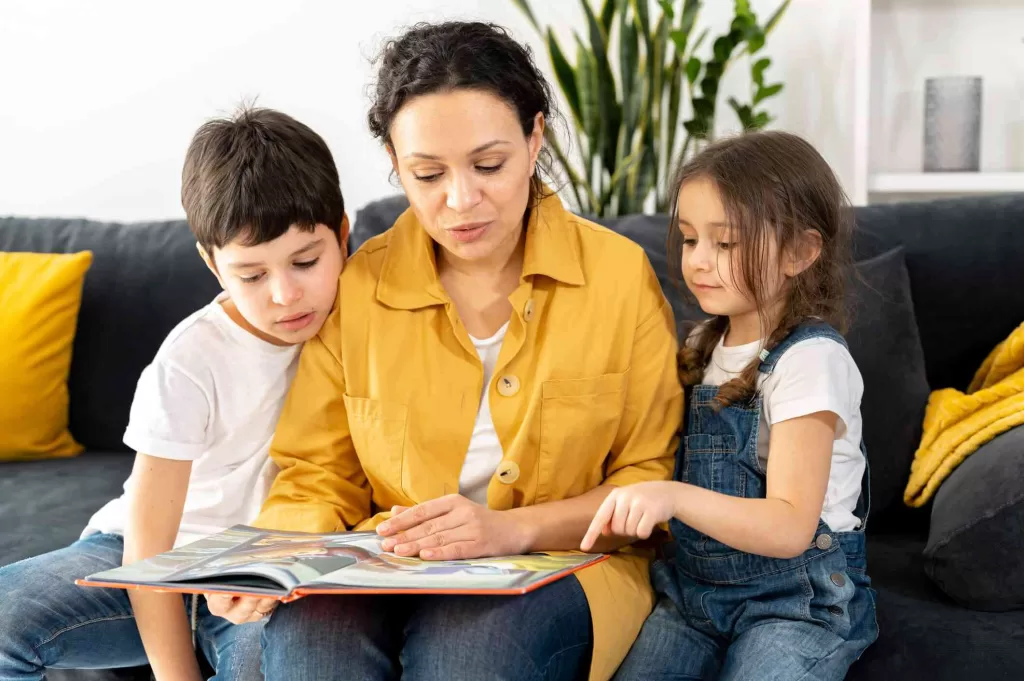 Seorang Ibu yang Sedang Membacakan Buku untuk Anak-Anaknya